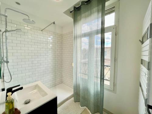 une salle de bain avec un lavabo et une douche dans l'établissement Chez Louis - Le Rémois Du Centre, à Reims