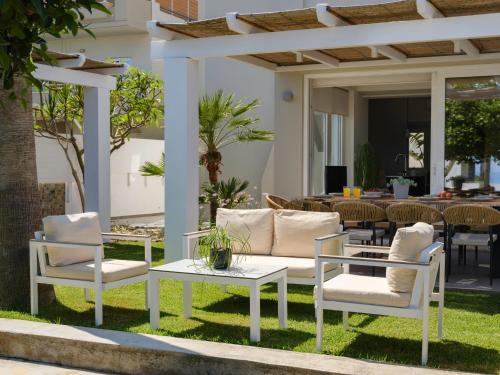 a patio with two chairs and a table and a couch at Sea La Vie in Adelianos Kampos