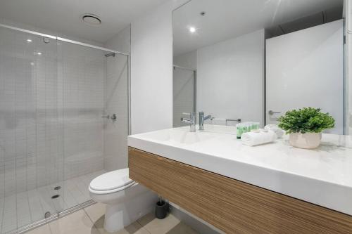 a bathroom with a sink and a toilet and a shower at Flinders Street Simplicity Overlooking the Yarra in Melbourne