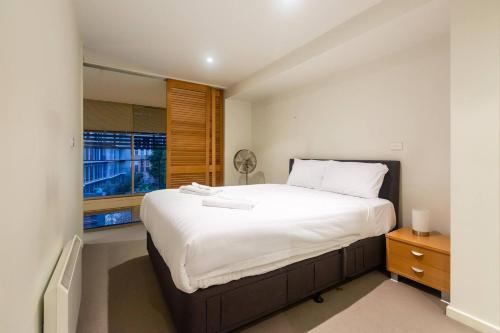 um quarto com uma cama grande e uma janela em New York Lofted CBD Retreat with Pool and Parking em Melbourne