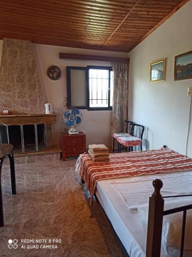 een slaapkamer met een bed, een tafel en een raam bij Villa Mira in Rizómilos