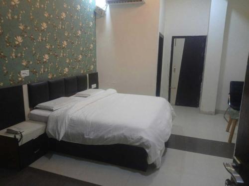 een slaapkamer met een bed en een muur bij OYO Hotel Rajdeep in Agra