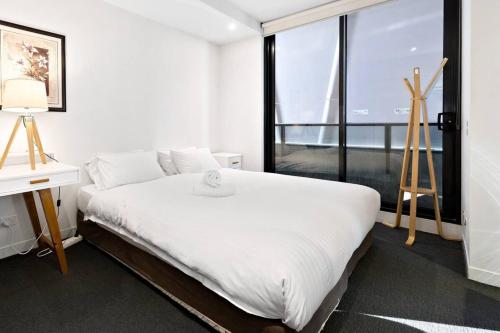 a white bedroom with a large bed and a window at 'Santeri' A Simple Stay with Modern Facilities in Melbourne