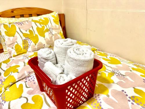 a basket of towels sitting on a bed at Tiny Private Room at the Upper Level of a Big House with Shared Bathroom in Seattle