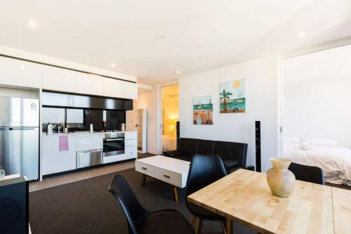 a kitchen and living room with a table and chairs at 'Santeri' A Simple Stay with Modern Facilities in Melbourne