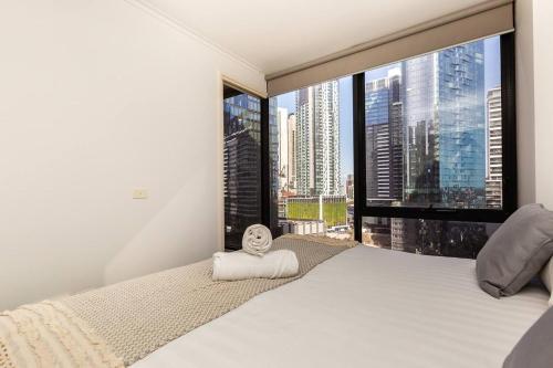 1 dormitorio con cama grande y ventana grande en A Modern Resort-style Stay near Crown Casino en Melbourne