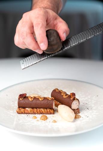 a person holding a spoon over a plate of food at InterContinental Bordeaux Le Grand Hotel by IHG in Bordeaux