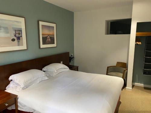 a bedroom with a large white bed with two pillows at The Lodge At Meyrick Park in Bournemouth