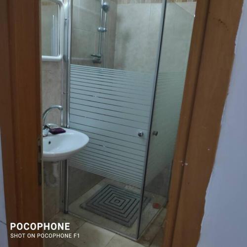 a shower with a glass door next to a sink at דירה פרטית מהממת מוארת. ממוזגת מרוהטת ומקסימה in Beer Sheva