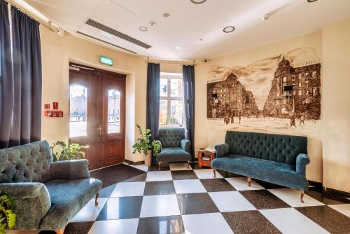 ヴロツワフにあるホテル ピアスト ヴロツワフ セントラムの椅子2脚と壁画のある待合室