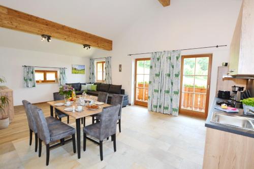 eine Küche und ein Wohnzimmer mit einem Tisch und Stühlen in der Unterkunft Wieserhof-Kampenwand in Bernau am Chiemsee