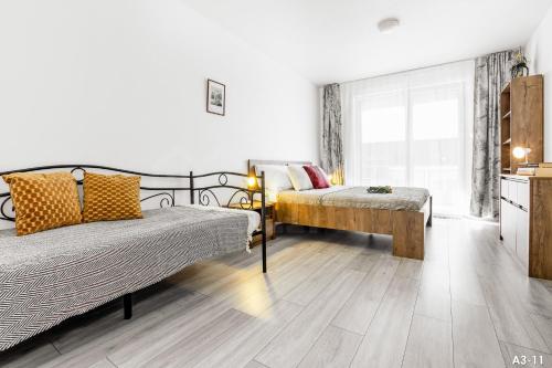 a bedroom with two beds and a table in it at KORZO Lipno in Lipno nad Vltavou