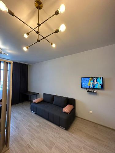 a living room with a couch and a flat screen tv at Pirosmani Mini Hotel in Batumi