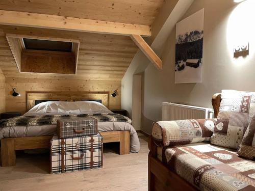 a bedroom with a bed and a couch at Odalys Chalet Le Chabichou in Les Deux Alpes