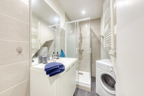 ein weißes Badezimmer mit einer Waschmaschine und einer Waschmaschine in der Unterkunft Le nid cosy • Proche Disneyland in Villiers-sur-Marne
