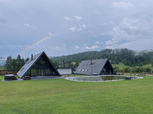 a large building in a field with a green field at Treeline Cabins in Cădăreşti