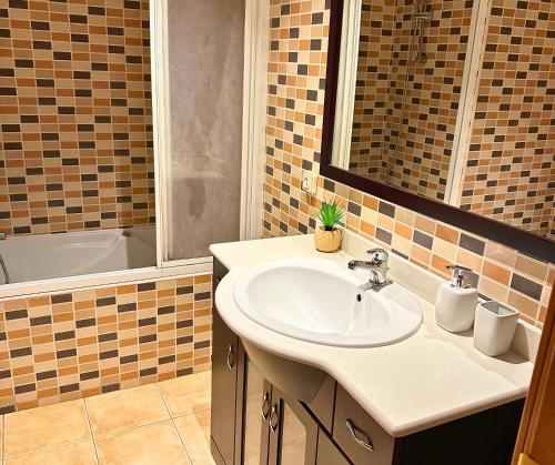 La salle de bains est pourvue d'un lavabo et d'une baignoire. dans l'établissement Apartamento con Piscina en Platja d'Aro by Host&Joy, à Platja d'Aro