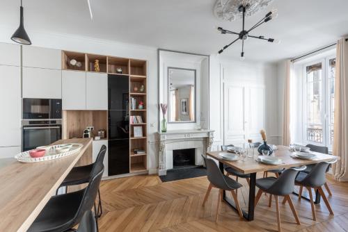 une cuisine et une salle à manger avec une table et des chaises dans l'établissement Le Merveilleux - Appt 111m2 au coeur de Lyon, à Lyon