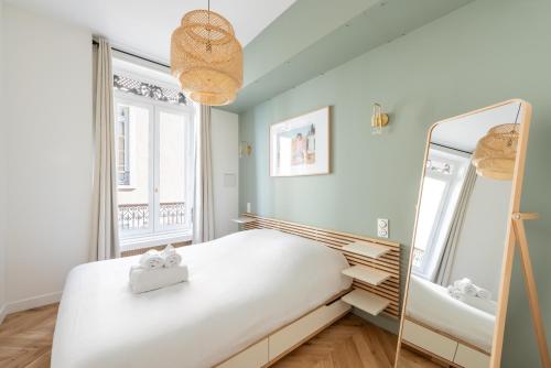 une chambre avec un lit et un miroir dans l'établissement Le Merveilleux - Appt 111m2 au coeur de Lyon, à Lyon