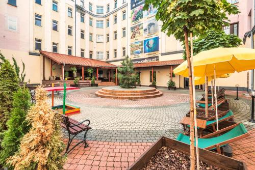 a building with a courtyard with a bench and an umbrella at Hotel Polonia Centrum in Wrocław
