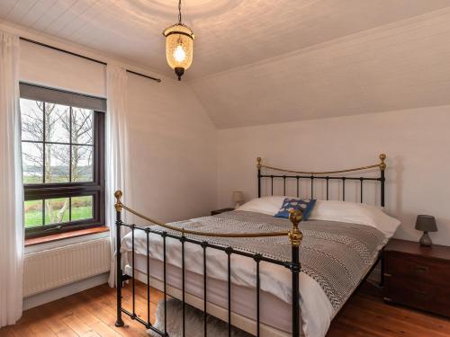 a bedroom with a bed and a window at The Schooner in Goleen