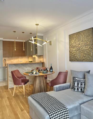 a living room with a bed and a table with chairs at NEW YORK - nowy apartament w centrum miasta - podziemny parking w cenie in Nowy Targ