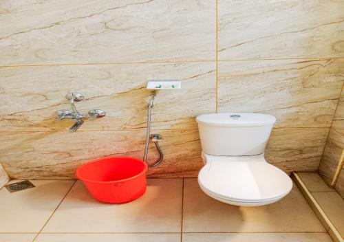 a bathroom with a toilet and a bucket at Vaiga Homes - Vembanadu Lakeview Retreat in Cochin