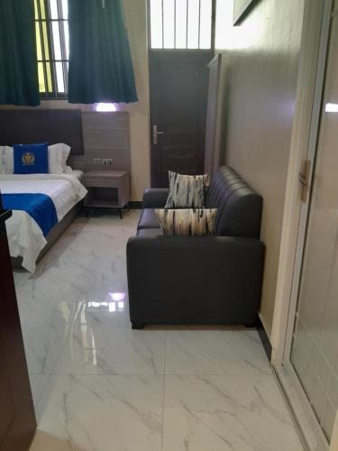 a living room with a couch and a bed at VEGAS LUXURY HOTEL in Dar es Salaam