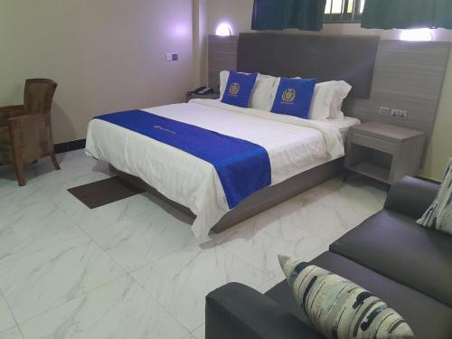 ein Schlafzimmer mit einem großen Bett und einem Sofa in der Unterkunft VEGAS LUXURY HOTEL in Daressalam