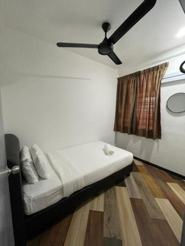 a bedroom with a bed with a ceiling fan at RNK BoutiQue HOTEL in Jitra
