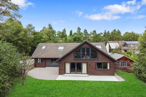 a wooden house with a green yard at Finest Retreats - The Logs in Fort William