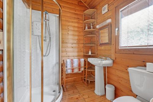a bathroom with a shower and a toilet and a sink at Finest Retreats - The Logs in Fort William