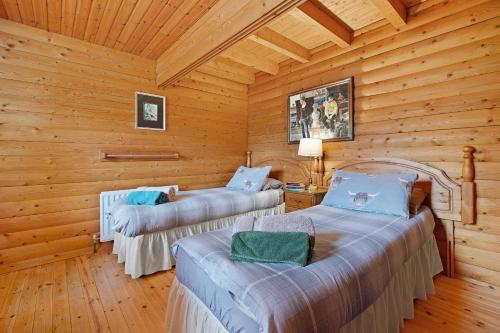 a bedroom with two beds in a log cabin at Finest Retreats - The Logs in Fort William