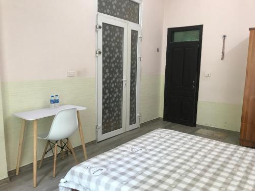 a room with a bed and a table and a door at 105 Láng Hạ in Hanoi