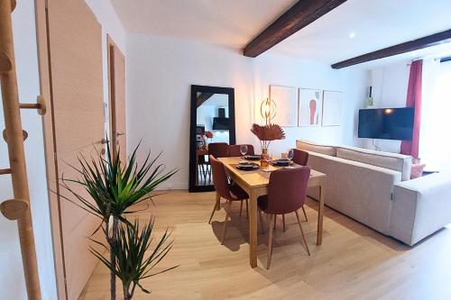 een woonkamer met een tafel en een bank bij ArtGold * Logement Haut de gamme Spa in Roanne