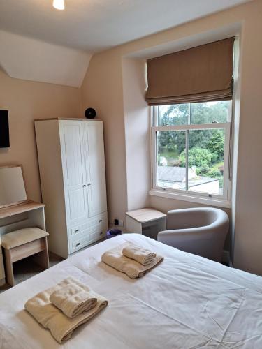 - une chambre avec un lit et 2 serviettes dans l'établissement Ferndale Lodge, à Ambleside