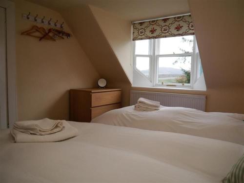 1 Schlafzimmer mit 2 weißen Betten und einem Fenster in der Unterkunft Bogroy in Aberlour