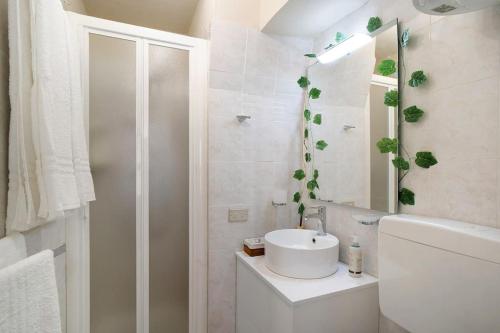 a white bathroom with a sink and a toilet at Casa della Nonna Teresa in Bordighera