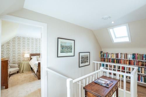 a room with a staircase with bookshelves at Kenmure Kennels in New Galloway