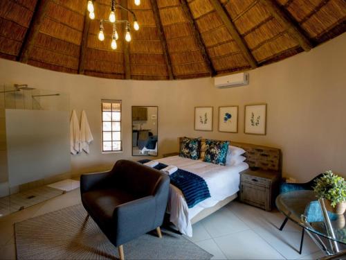 een slaapkamer met een bed en een stoel in een kamer bij Mambakloof Country Estate in Vrede