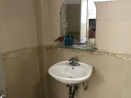 a white sink in a bathroom with a mirror at 105 Láng Hạ in Hanoi