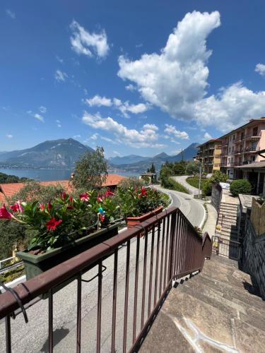 een balkon met bloempotten op een reling en een weg bij Casa NiMa Lake Apartment in Perledo
