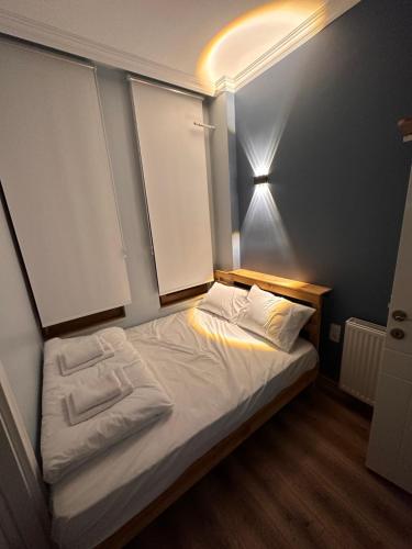a small bedroom with a bed with white sheets at Red 8 Suite FLR1 in Istanbul