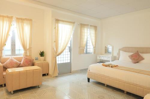 une chambre avec un lit, un canapé et des fenêtres dans l'établissement LA VIE EN ROSE 2 Hotel, à Đà Lạt