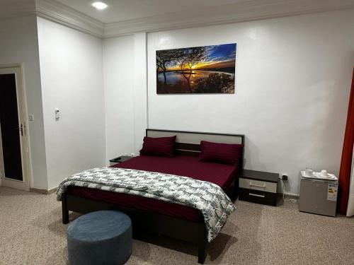 1 dormitorio con 1 cama y una foto en la pared en Chambres d'hôte centre ville en Dakar