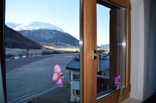 a window with a view of a snow covered mountain at Residence Miragolf in Madulain