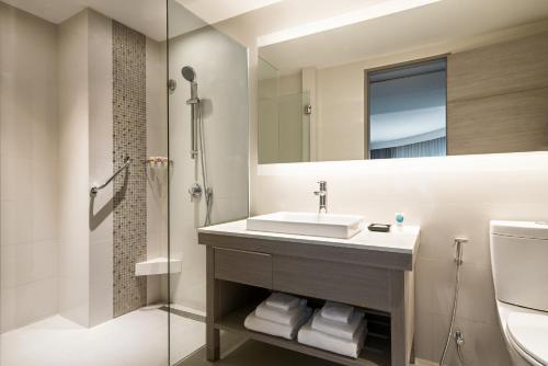 a bathroom with a sink and a toilet and a mirror at Hyatt Place Bangkok Sukhumvit - SHA Extra Plus Certified in Bangkok