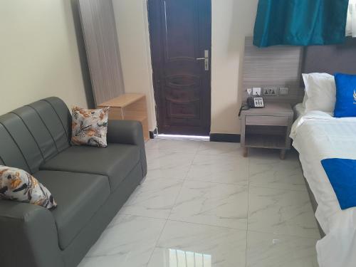 a living room with a couch and a bed at VEGAS LUXURY HOTEL in Dar es Salaam