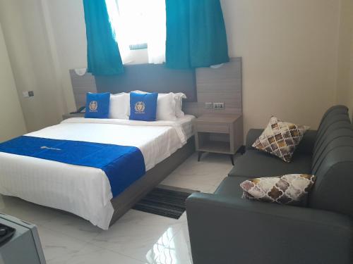 a bedroom with a bed and a couch at VEGAS LUXURY HOTEL in Dar es Salaam