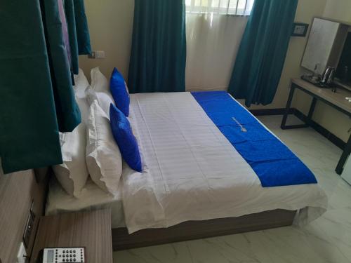 a bedroom with a large bed with blue pillows at VEGAS LUXURY HOTEL in Dar es Salaam